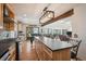 Modern kitchen opens to the living room, featuring natural wood cabinets, black countertops, and a large island at 10756 Timothys Dr, Conifer, CO 80433