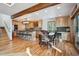 Open-concept kitchen and dining area features natural wood cabinets, a breakfast bar, and hardwood floors at 10756 Timothys Dr, Conifer, CO 80433