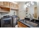 Laundry room featuring a sink with granite countertops, wood cabinets, and a washer and dryer at 10756 Timothys Dr, Conifer, CO 80433