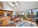 Bright living room with vaulted ceilings, skylights, hardwood floors, and access to an outdoor deck at 10756 Timothys Dr, Conifer, CO 80433