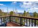 Breathtaking mountain view from a wooden deck with black railing and trees at 10756 Timothys Dr, Conifer, CO 80433