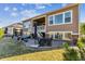 The rear exterior shows a covered patio and stone accents adding charm to the residence's design at 8651 S De Gaulle Ct, Aurora, CO 80016