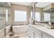 Bathroom featuring a soaking tub, white cabinets, vanity, and frameless shower at 8651 S De Gaulle Ct, Aurora, CO 80016