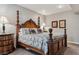 Spacious bedroom features a wooden four-post bed, complemented by neutral wall paint and framed artwork at 8651 S De Gaulle Ct, Aurora, CO 80016