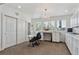 Bright craft room featuring a sewing table, chandelier, window views, and ample storage space at 8651 S De Gaulle Ct, Aurora, CO 80016
