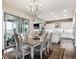 Elegant dining room featuring a chandelier, stylish furniture, and seamless access to the outdoors at 8651 S De Gaulle Ct, Aurora, CO 80016