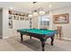 Spacious game room with a pool table under stylish lighting and built-in shelving for décor at 8651 S De Gaulle Ct, Aurora, CO 80016