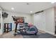 Home gym with an elliptical machine, free weights, TV, and mirrored wall for a complete workout space at 8651 S De Gaulle Ct, Aurora, CO 80016