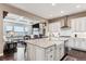 Open kitchen design with a large island, white cabinets, and stainless steel appliances at 8651 S De Gaulle Ct, Aurora, CO 80016