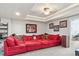 Cozy living room with a large red sectional sofa, decorative pillows, and Gathering photos on the wall at 8651 S De Gaulle Ct, Aurora, CO 80016