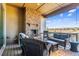 Covered outdoor patio with a stone fireplace, comfortable seating, and scenic views of the neighborhood at 8651 S De Gaulle Ct, Aurora, CO 80016