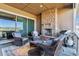 Inviting outdoor patio area with a stone fireplace, comfortable seating, and a barbecue grill for entertaining at 8651 S De Gaulle Ct, Aurora, CO 80016