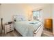 A well-lit bedroom with hardwood floors, a large bed, and a white vanity with a bright window view at 18578 E Whitaker Cir # A, Aurora, CO 80015