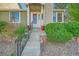 Charming front entrance with gray stone steps, red flower pots, and freshly planted green foliage at 18578 E Whitaker Cir # A, Aurora, CO 80015