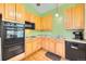 The kitchen has wooden cabinets, black appliances, granite countertops, and hardwood flooring at 18578 E Whitaker Cir # A, Aurora, CO 80015