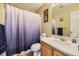 Bathroom featuring a vanity with white sink, wood cabinets and a blue/gray shower curtain at 10065 Cairns Ct, Highlands Ranch, CO 80130