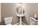 Powder room featuring pedestal sink, decorative mirror, and storage basket at 10065 Cairns Ct, Highlands Ranch, CO 80130
