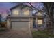 Charming two-story home boasts a well-manicured lawn, brick accents, and a cozy front porch perfect for enjoying the evening sunset at 10065 Cairns Ct, Highlands Ranch, CO 80130