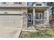 The front of the house boasts brick accents around the garage door and front porch, and white porch rails at 10065 Cairns Ct, Highlands Ranch, CO 80130