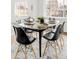 Well-lit dining room featuring a glass table, modern chairs, a geometric rug, and bright windows at 4110 W Floyd Ave, Denver, CO 80236