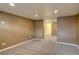 Open basement with neutral carpet and lighting, providing a versatile space for various uses at 2389 Nome St, Aurora, CO 80010