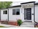 Charming white home featuring a modern black front door and well-maintained landscaping at 2389 Nome St, Aurora, CO 80010