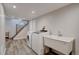 Functional laundry room with modern washer, dryer, sink, and convenient access to the staircase at 2389 Nome St, Aurora, CO 80010