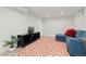 Finished basement offers cozy seating area with vinyl flooring and an orange patterned rug, perfect for relaxing at 8390 E Davies Pl, Centennial, CO 80112
