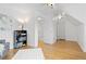 An open bedroom with light hardwood floors, complemented by a sleek gray sofa and a stylish black bookshelf at 8390 E Davies Pl, Centennial, CO 80112