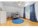 Cozy bedroom with hardwood floors, accented by a playful car-themed design, blue rug and bright, natural light at 8390 E Davies Pl, Centennial, CO 80112