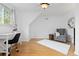 Bright bedroom featuring hardwood floors, modern white desk, and a comfortable gray armchair near the window at 8390 E Davies Pl, Centennial, CO 80112