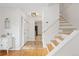 Bright foyer with hardwood floors and a staircase, creating a welcoming entrance to the home at 8390 E Davies Pl, Centennial, CO 80112