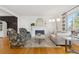 Bright living room with a white-painted brick fireplace, stylish decor, and a view to other parts of the home at 8390 E Davies Pl, Centennial, CO 80112
