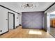 Spacious living room featuring hardwood floors, accent wall, and a sliding glass door at 1060 W 133Rd Cir # C, Denver, CO 80234