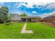 Well-maintained backyard with a large lawn, patio with hot tub, and charming landscaping for outdoor enjoyment at 10009 Dodge Dr, Northglenn, CO 80260