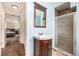 Well-lit bathroom features a wood vanity with sink and a walk-in shower, offering a clean and functional space at 10009 Dodge Dr, Northglenn, CO 80260