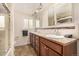 Bathroom features double sinks, neutral countertops, tile flooring and large framed mirror at 10009 Dodge Dr, Northglenn, CO 80260