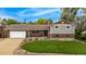 Charming home featuring a well-manicured lawn, brick accents, and an attached garage at 10009 Dodge Dr, Northglenn, CO 80260