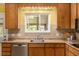 Sunlit kitchen with stainless dishwasher, neutral countertops, cabinets and natural light at 10009 Dodge Dr, Northglenn, CO 80260