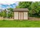 Backyard shed for extra storage space, nestled amongst green lawn, mature trees and landscape at 10009 Dodge Dr, Northglenn, CO 80260