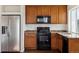 Bright kitchen featuring wood cabinets, dark countertops, and stainless steel appliances at 5383 Andes St, Denver, CO 80249