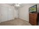 Bedroom featuring neutral carpet, closet, ceiling fan, and a wooden dresser with television at 5009 Mt Osage St, Frederick, CO 80504