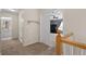 Hallway with carpet flooring leads to bedroom with ceiling fan via a white door at 5009 Mt Osage St, Frederick, CO 80504