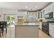Bright kitchen with a center island, granite countertops, white cabinetry, stainless steel appliances, and hardwood floors at 5009 Mt Osage St, Frederick, CO 80504