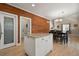 Kitchen island with hardwood floors leading to dining area with natural wood accent wall at 5009 Mt Osage St, Frederick, CO 80504