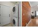 Well lit laundry room features a stacked washer and dryer along with wood accent wall at 5009 Mt Osage St, Frederick, CO 80504