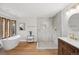 Bright bathroom features a modern tub, walk-in shower, and stylish vanity, complemented by wood floors at 10114 Meade Ct, Westminster, CO 80031