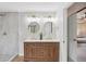 Double sink bathroom with stylish round mirrors, wood vanity, marble countertop and seamless glass shower door at 10114 Meade Ct, Westminster, CO 80031
