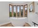 Bathroom displaying a modern tub under tall windows, bright light fixtures, and tasteful artwork on the wall at 10114 Meade Ct, Westminster, CO 80031