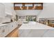 Bright kitchen boasts white cabinets, a large marble island, and wood flooring at 10114 Meade Ct, Westminster, CO 80031